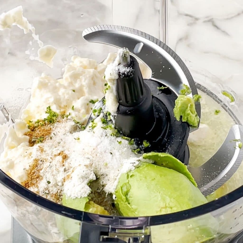 Food processor with avocado, mayonnaise and spices.