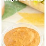 Bowl of sauce and a sandwich.