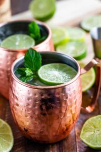 Copper cup filled with drink and lime.