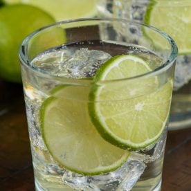Glass with gin and lime slices.