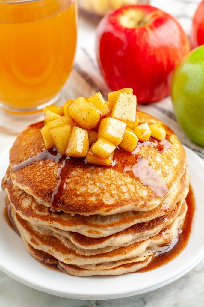 Stack of pancakes topped with diced apples.