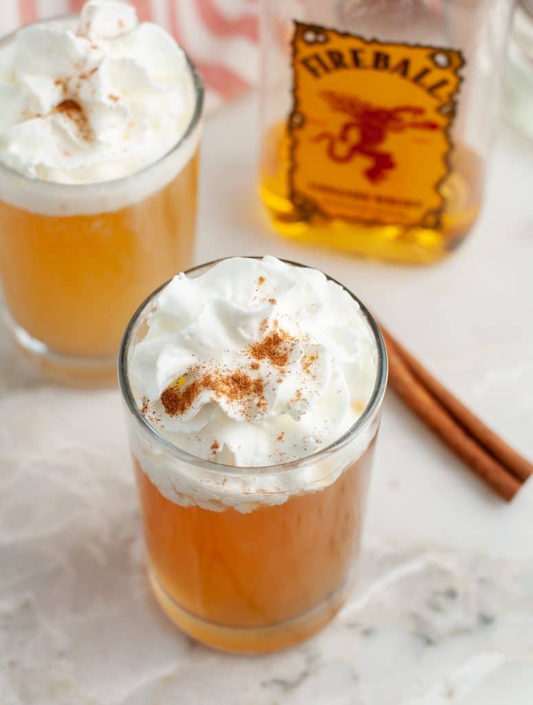 Glass with apple cider and whipped cream.