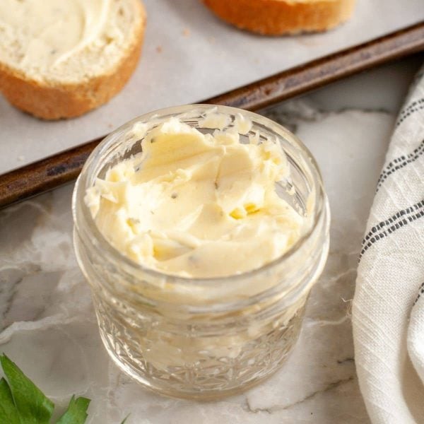 Butter in a jar with slices of toast.