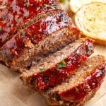 Sliced meatloaf on a board with toast.