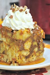 Crockpot French Toast Casserole topped with whipped cream sitting on a white plate
