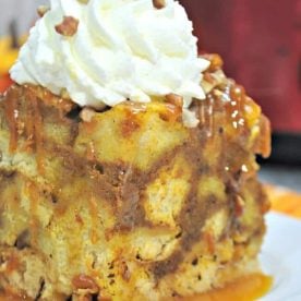 Crockpot French Toast Casserole topped with whipped cream sitting on a white plate