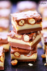Square Pieces of Nut Goodie Bars stacked on top of each other on a plate