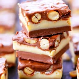 Square Pieces of Nut Goodie Bars stacked on top of each other on a plate