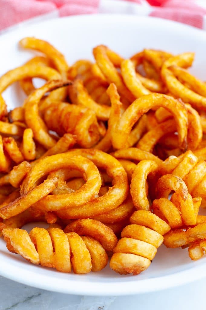 Curly French fries in a bowl.