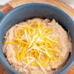 Bowl of refried beans topped with cheese.