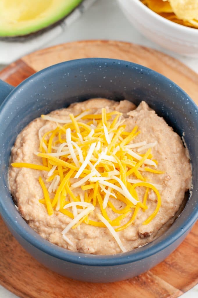 Bowl of refried beans topped with cheese.