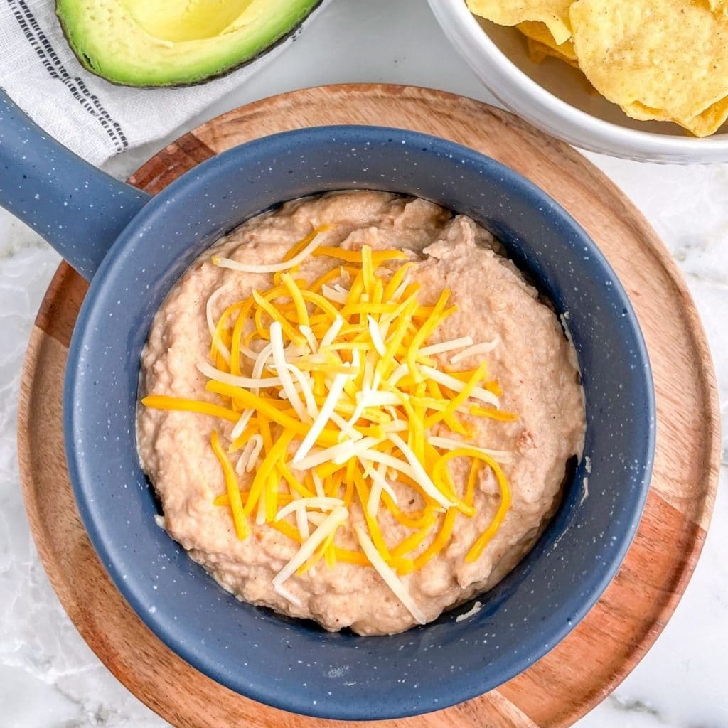 Bowl of beans topped with cheese.