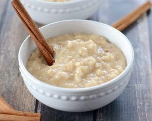 Bowl of rice pudding with cinnamon stick.