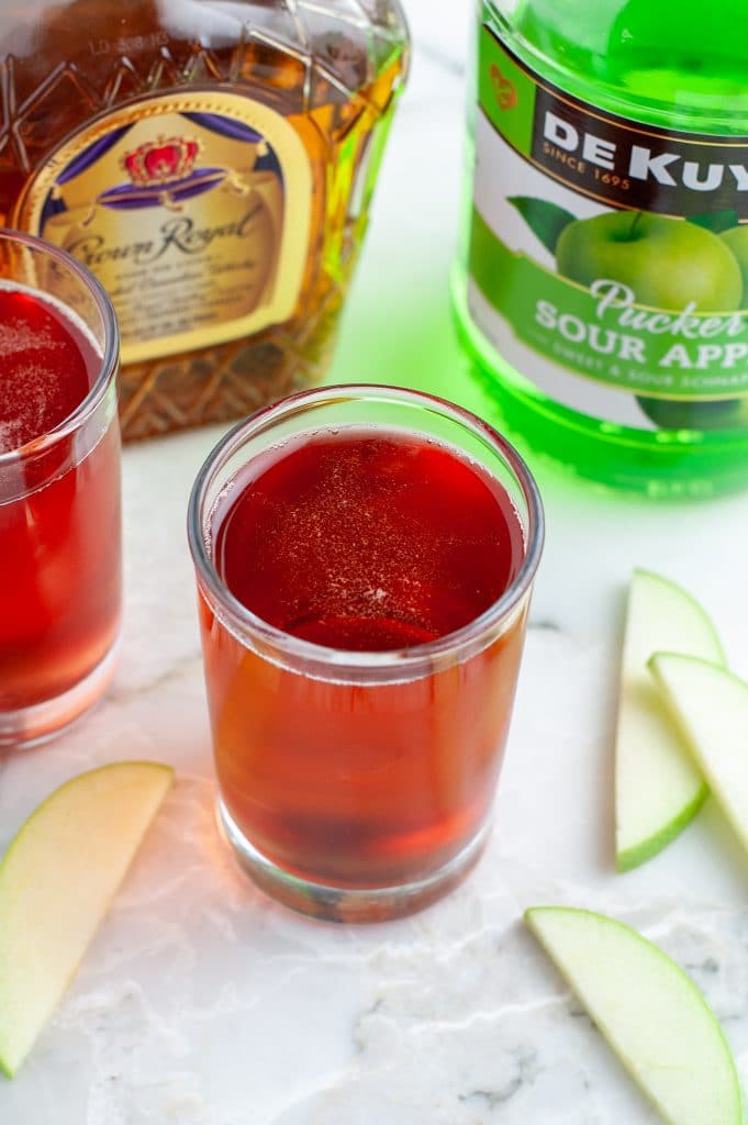 Bottles of liquor and shot glass filled with juice.