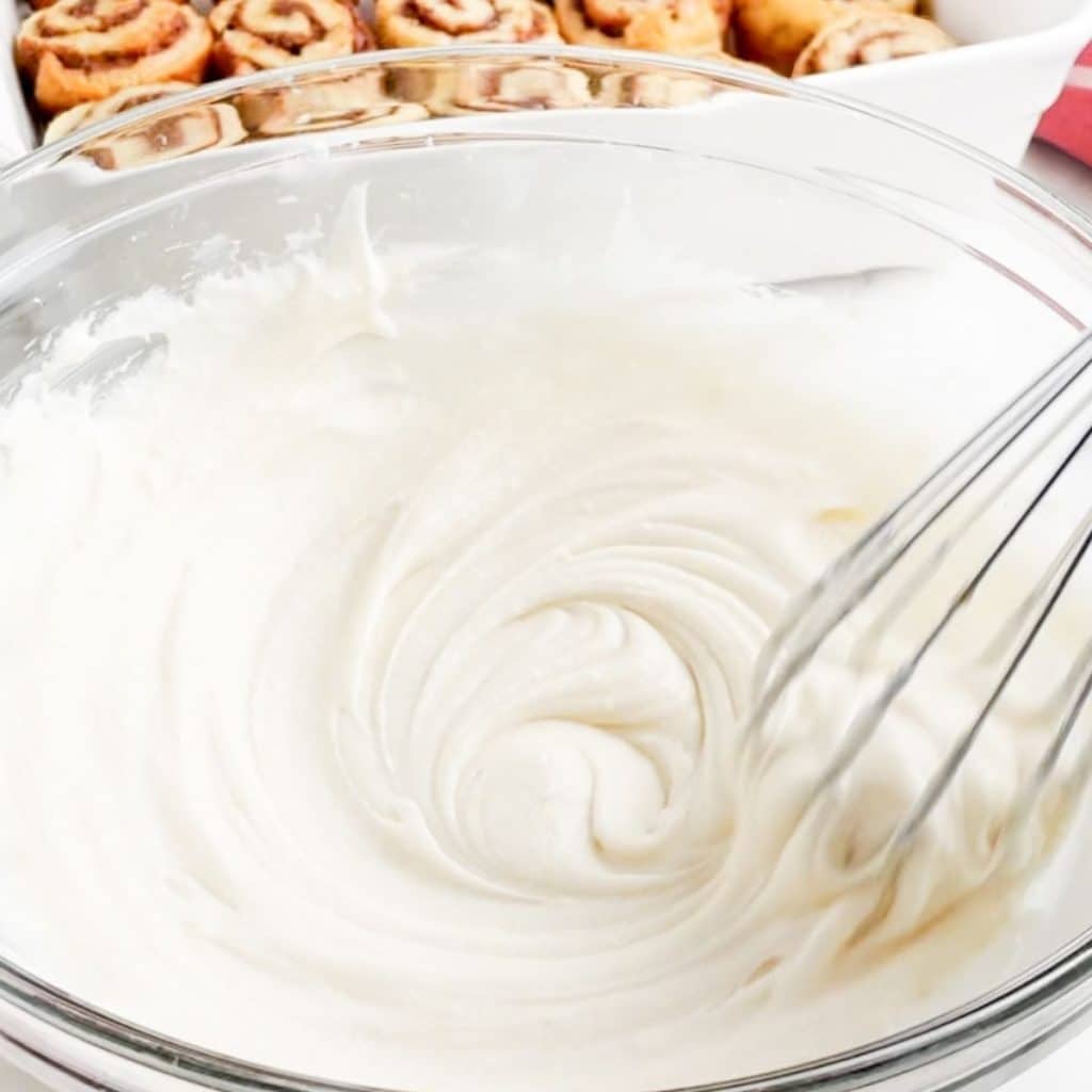Bowl of frosting with whisk.