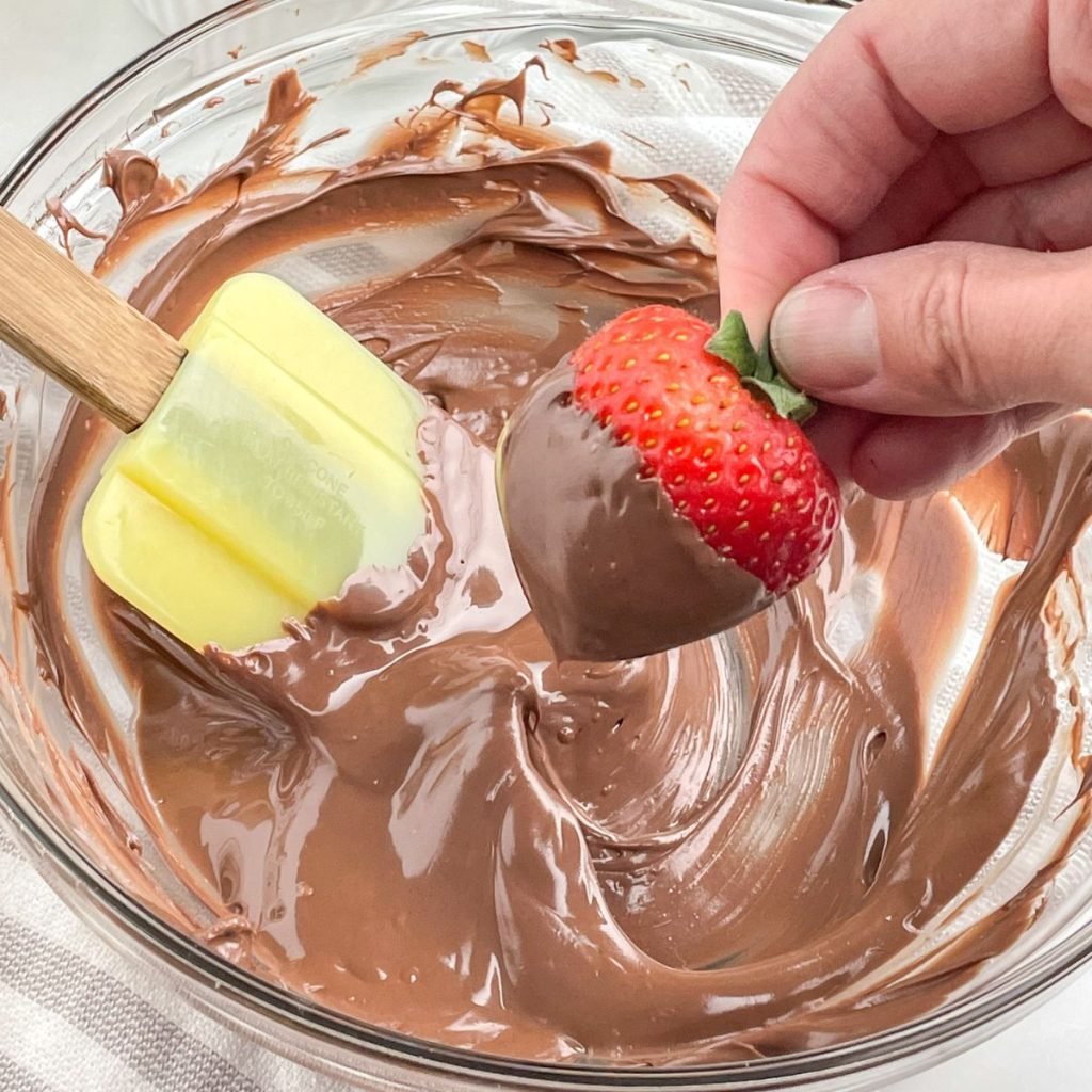 Melted chocolate in a bowl with a strawberry.