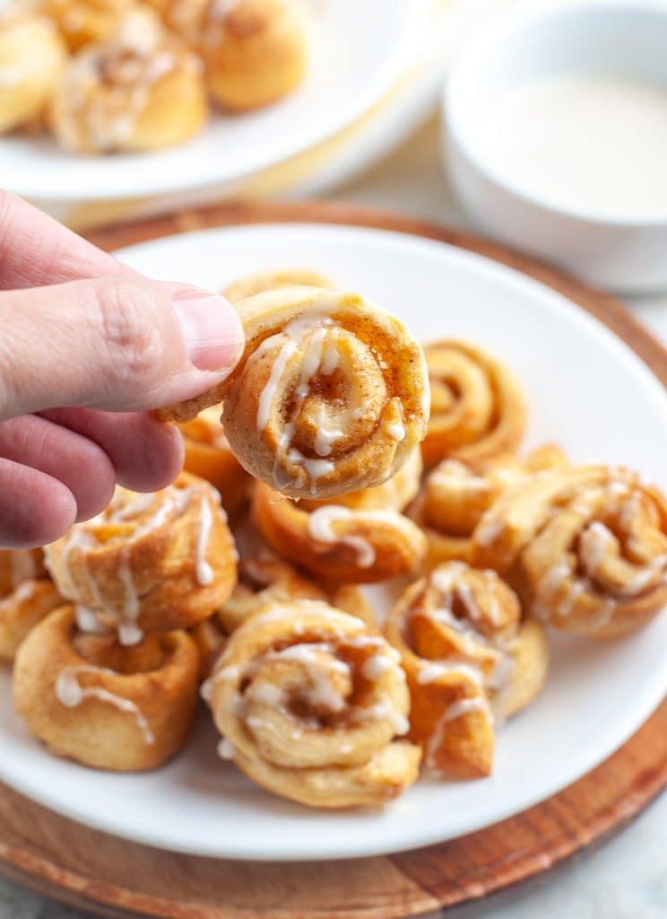 Hand holding cinnamon roll. 