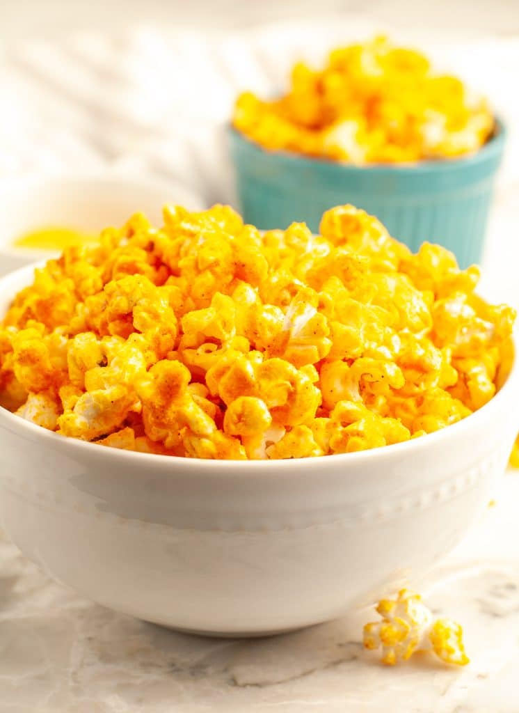 Two bowls of cheesy popcorn.