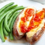 Plate of sausages and cheese with green beans.