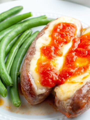 Plate of sausages and cheese with green beans.