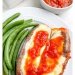 Plate of sausages with cheese and green beans.