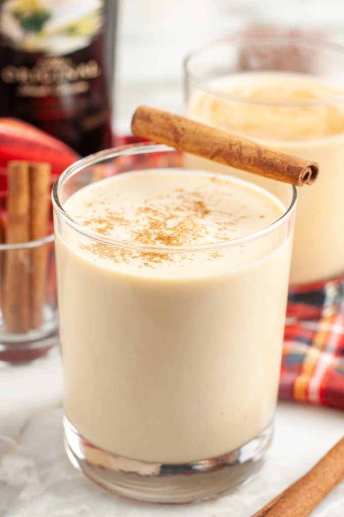 Glass of eggnog and cinnamon stick.