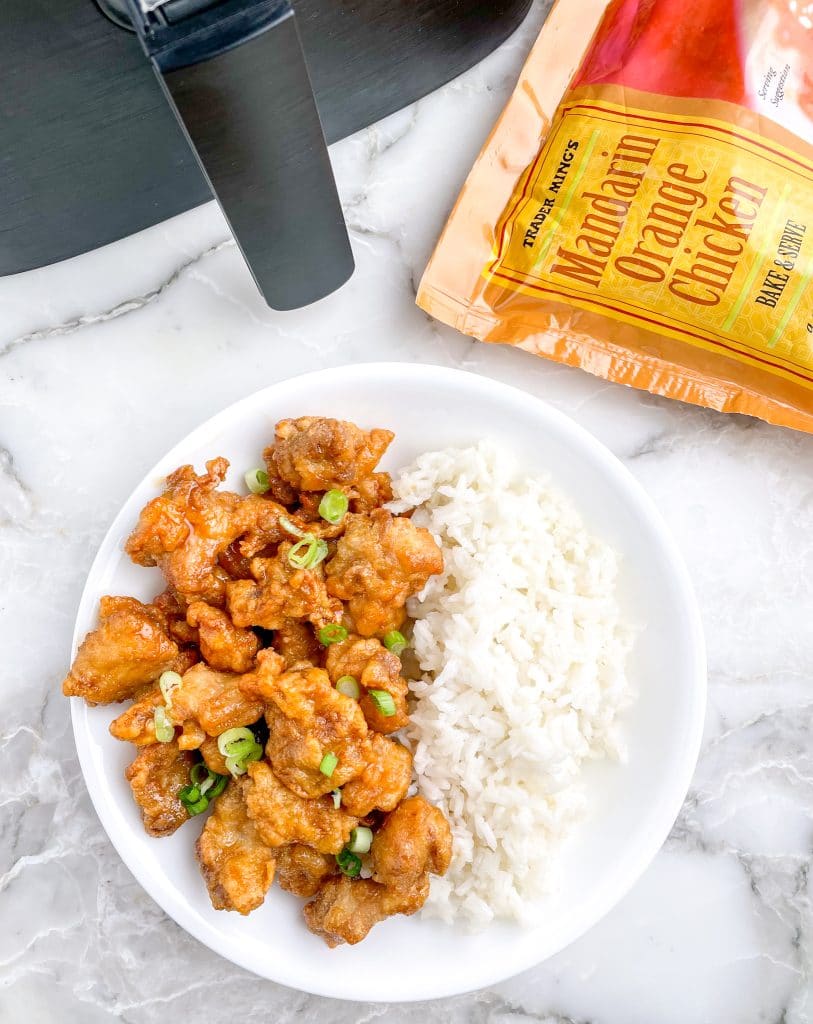Bowl of orange chicken and an air fryer.