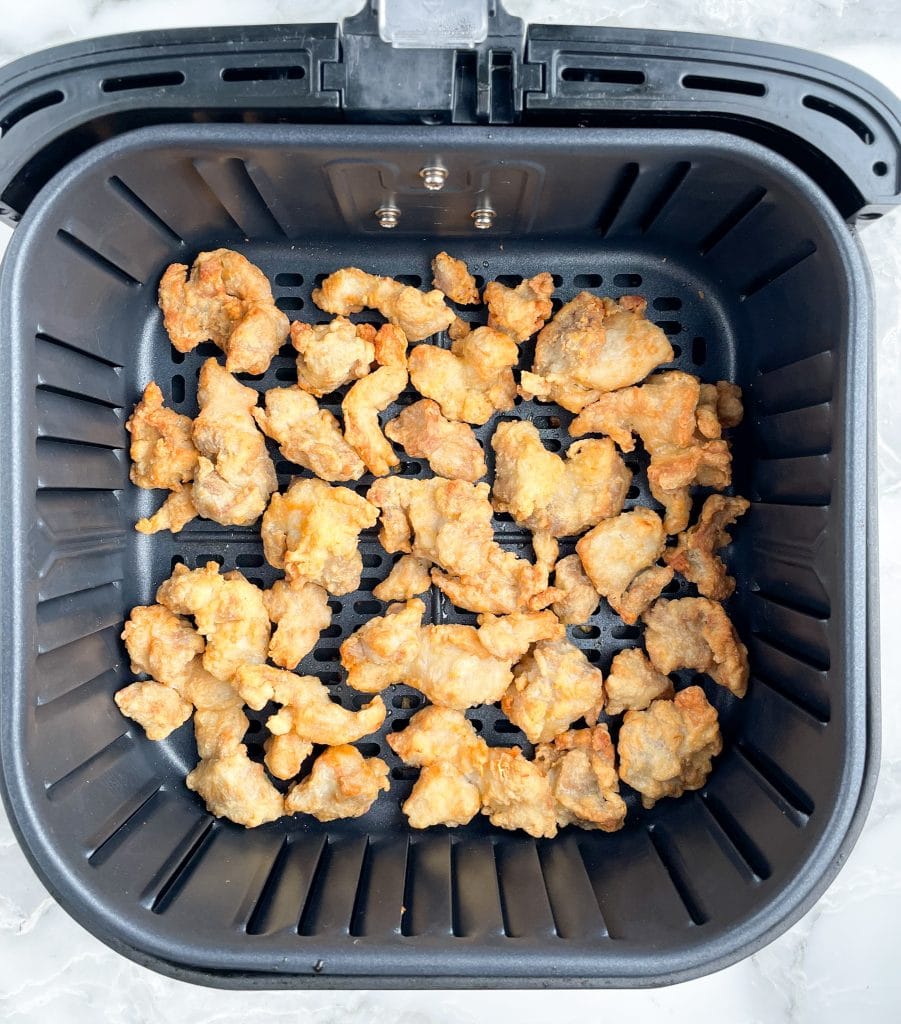 Chicken in air fryer basket.