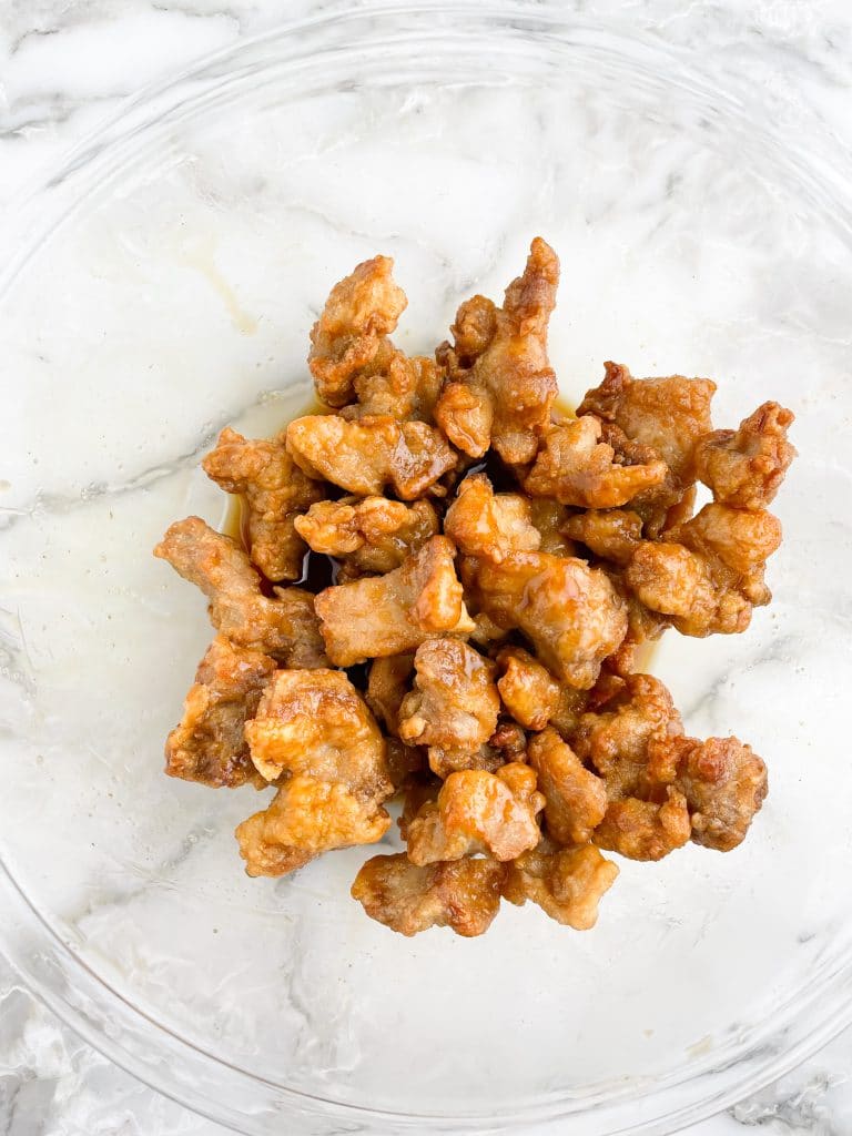 Fried chicken nuggets in sauce in a bowl.