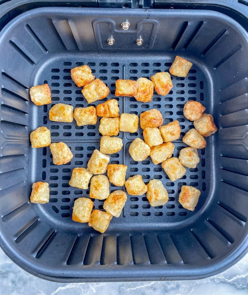 Cooked gnocchi in air fryer basket.