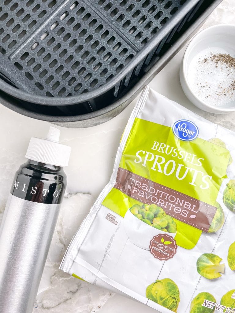 Air fryer basket, oil mister, bag of frozen brussel sprouts.