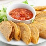 Plate of mini tacos with bowl of salsa.