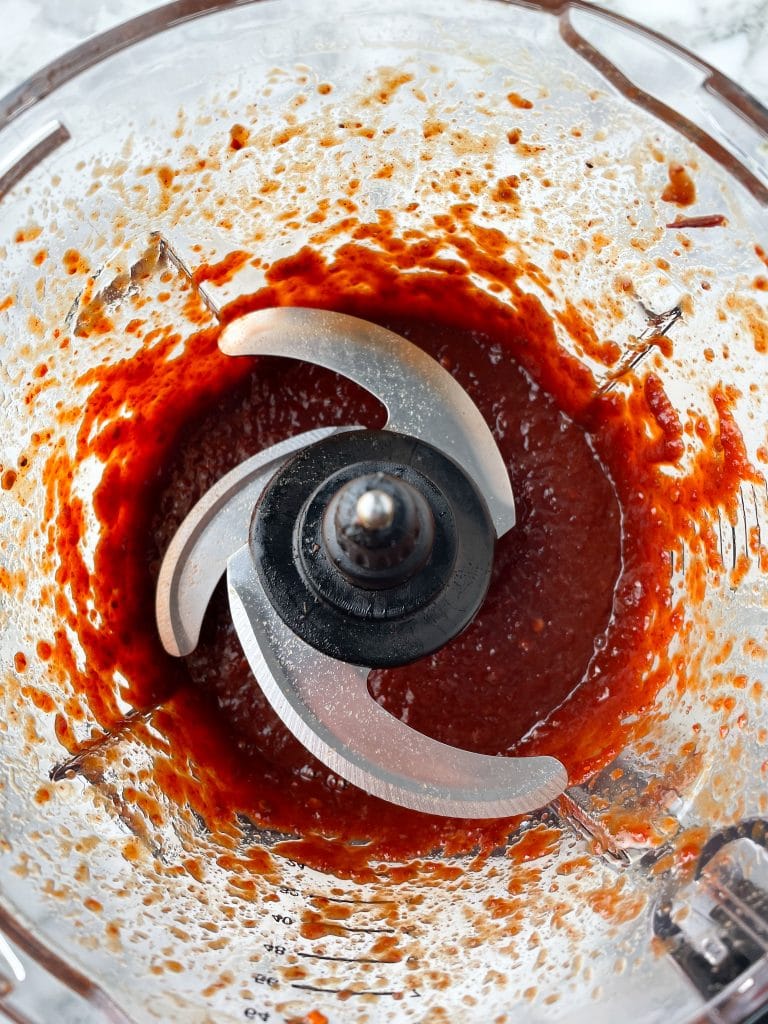 Food processor filled with red sauce.