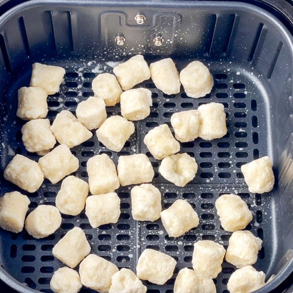 Frozen gnocchi in air fryer basket. 