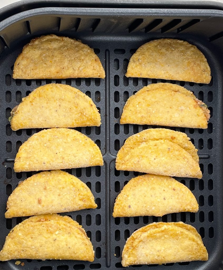 Mini tacos in air fryer basket.