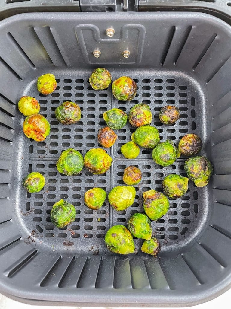 Roasted brussels sprouts in air fryer basket.