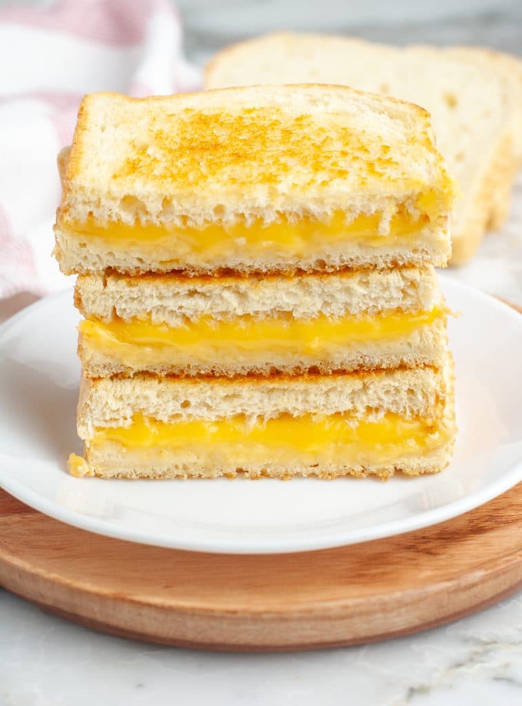 Stacked grilled cheese sandwiches on a plate.