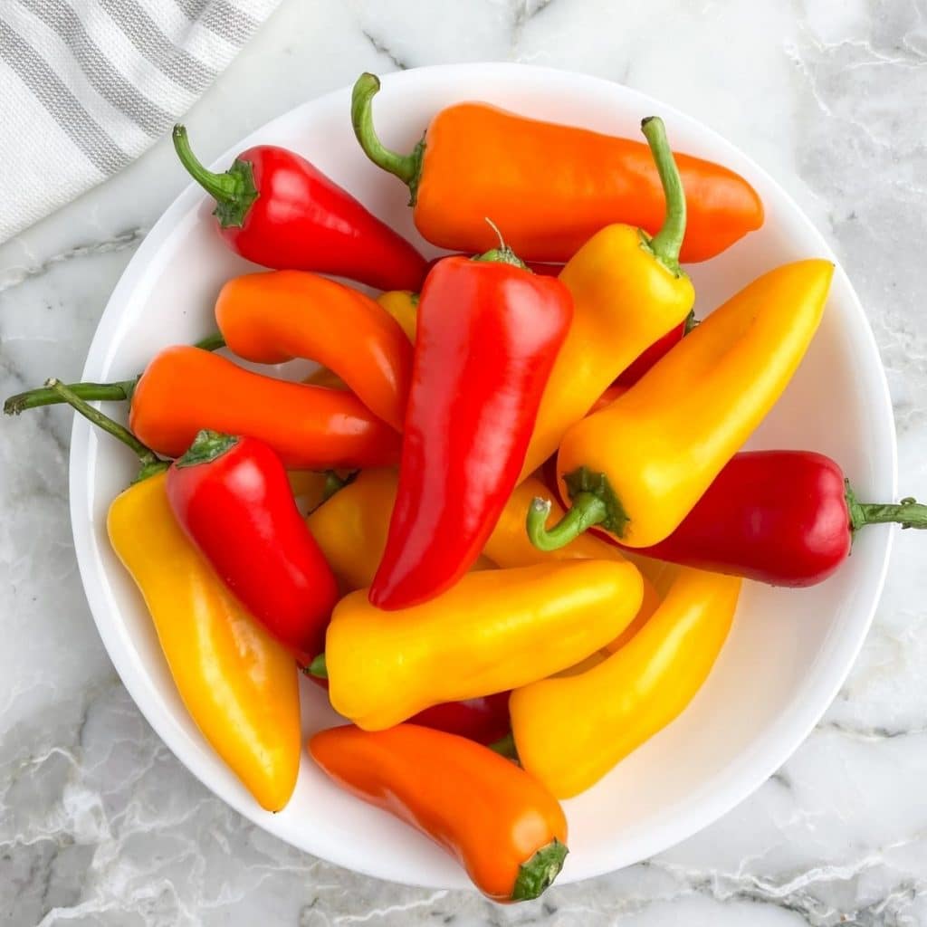 Bowl of red, yellow, and orange mini peppers.