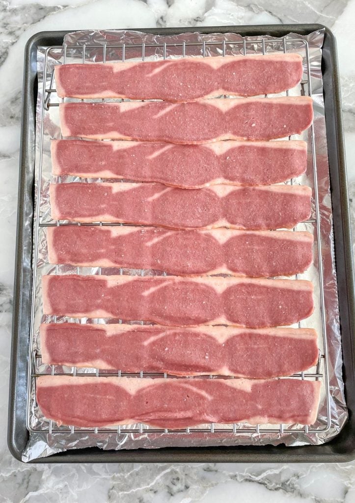 Uncooked turkey bacon on cookie sheet.