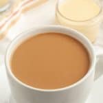 Cup of coffee and jar with cream.