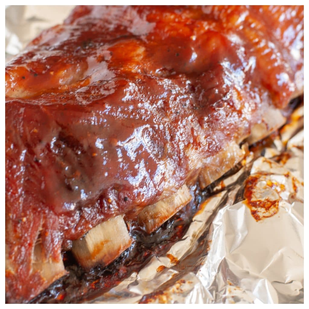 Cooked ribs with BBQ sauce in foil.