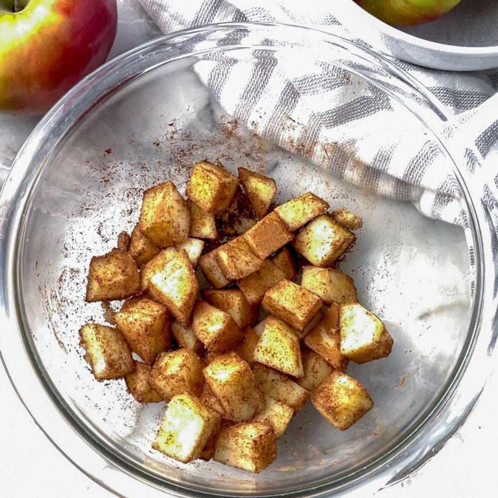 Diced apples with cinnamon in a bowl.