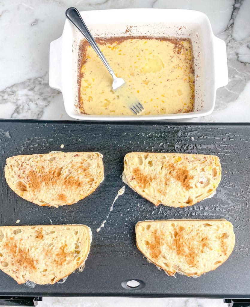 Egg mixture in dish with french toast on a griddle.