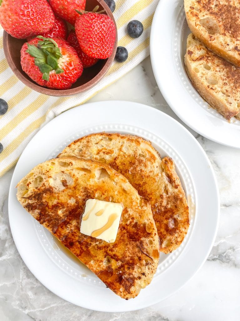 Plate with french toast and bowl of strawberries. 