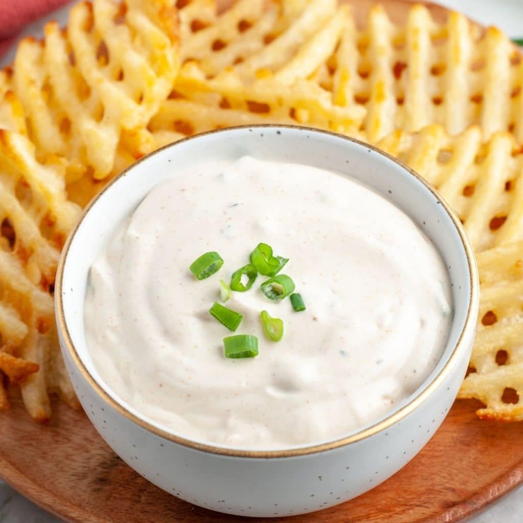 Bowl of sour cream dip and waffle fries.