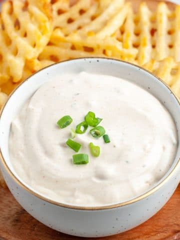 Bowl of sour cream dip and waffle fries.