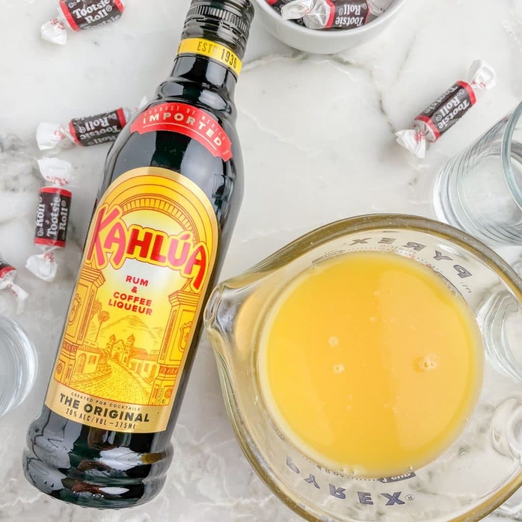 Bottle of Kahlua and glass of orange juice.