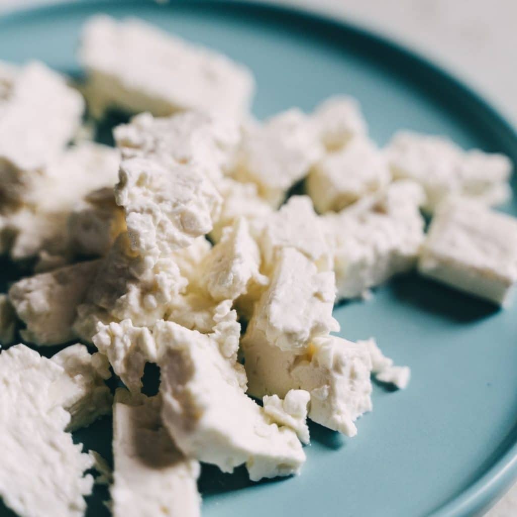 Crumbled cheese on blue plate.