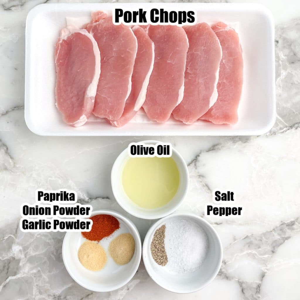 Pork chops and bowl of oil and seasonings. 