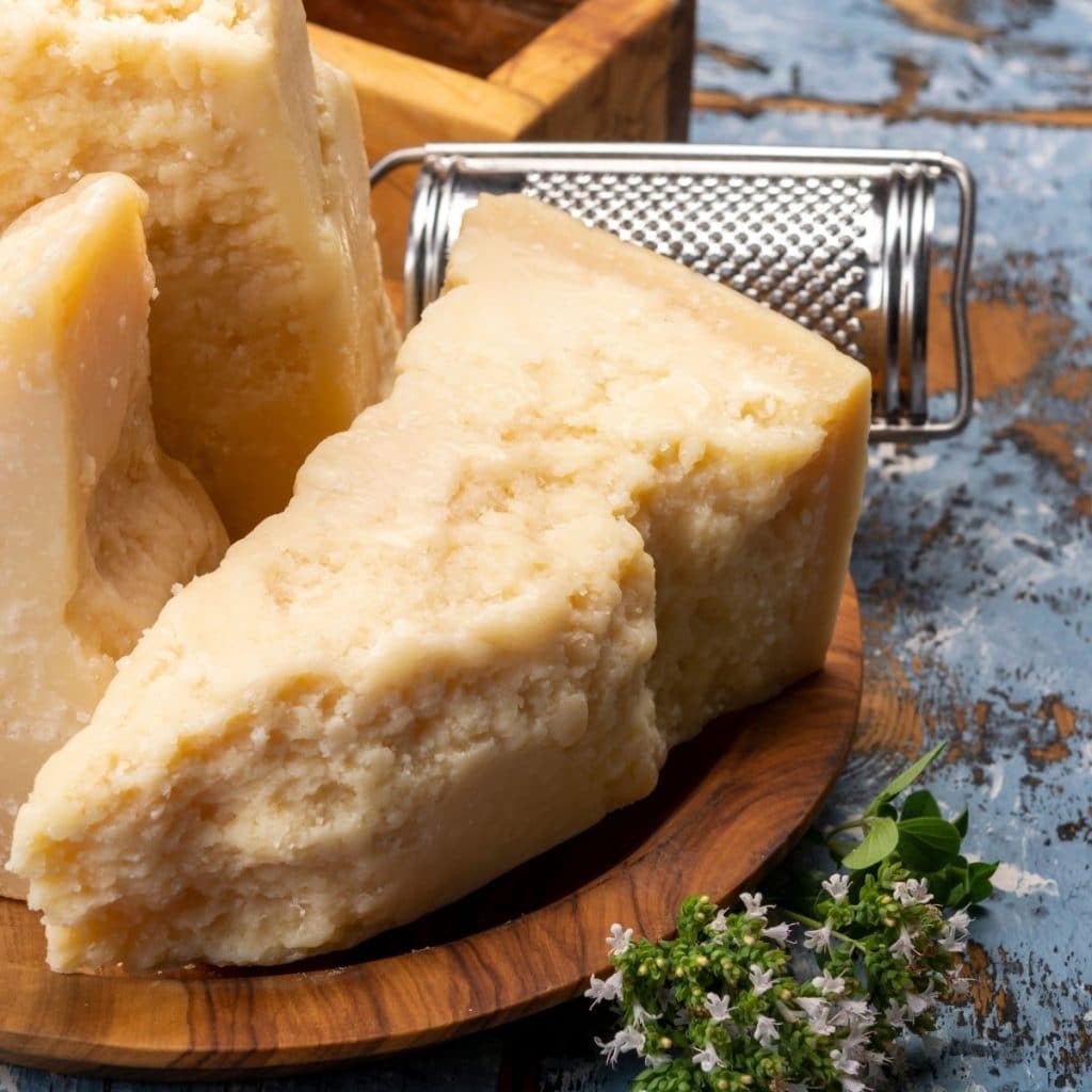 Wedge of cheese on a wooden plate.